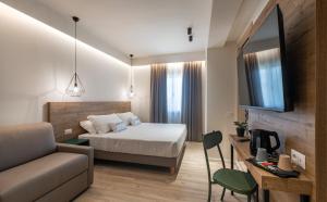 グッビオにあるCatignano Hotel Ristoranteのベッドとソファ付きの小さなホテルルーム