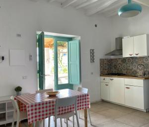 cocina y comedor con mesa y sillas en Appartamenti Alba&Tramonto, en Stromboli