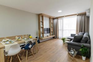 a living room with a couch and a table at Burgas Beach Resort 2 Apartments in Burgas City