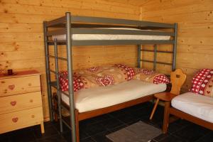 Zimmer mit Etagenbett und 2 Etagenbetten in einer Hütte in der Unterkunft Pilger-Hüttli - Blockhaus in Schönengrund