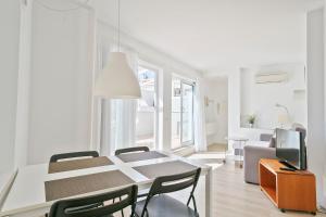 a white dining room with a table and chairs at Apartaments Pepita Bandert in Cambrils