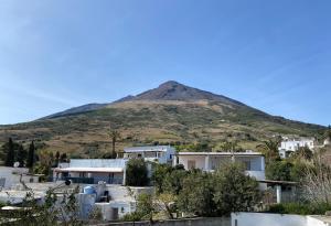 a mountain in the distance with houses and trees at Appartamenti Alba&Tramonto in Stromboli