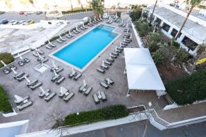 uma vista superior para uma piscina com espreguiçadeiras e sidx sidx em Vrissaki Hotel Apartments em Protaras