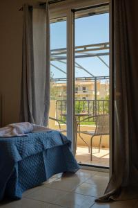 a bedroom with a bed in front of a sliding glass door at Morfis Getaway Apartment in Zakynthos Town