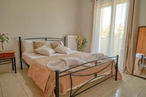 a bedroom with a bed with pillows and a window at Morfis Getaway Apartment in Zakynthos