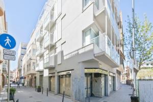 un edificio blanco con balcones en una calle en Apartamentos Pepita Bandert, en Cambrils