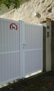 une clôture blanche avec un portail muni d'un panneau de sécurité. dans l'établissement chambre d'hôtes proche PUY DU FOU, à Le Pin