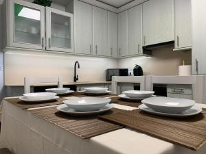 una cocina con una mesa con platos blancos. en Lucky home en Pontevedra