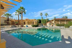 a swimming pool with palm trees and a house at La Quinta Inn by Wyndham Phoenix North in Phoenix