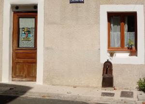 budynek z drzwiami i skrzynką pocztową przed nim w obiekcie Charmant Studio dans l’Ancienne Mairie w mieście Saint-Laurent-le-Minier