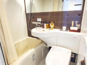 a small bathroom with a sink and a toilet at HOTEL LiVEMAX Yokohama Stadium Mae in Yokohama