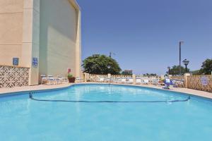 a large swimming pool in a hotel with chairs at La Quinta by Wyndham Charleston Riverview in Charleston