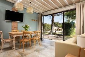 a dining room with a table and chairs and a tv at San Francesco Country Resort in Vada