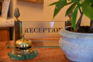a little bell sitting on a table next to a potted plant at Grand Hotel Terme di Augusto in Ischia +87 photos