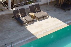 a group of chairs and a table next to a pool at Costa Maya Bodrum in Bodrum City