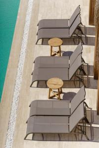 a row of chaise lounge chairs and a wooden table at Costa Maya Bodrum in Bodrum City