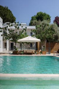 a pool with an umbrella and a table and an umbrella at Costa Maya Bodrum in Bodrum City