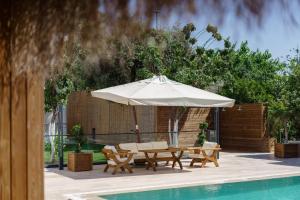 a patio with a table and an umbrella next to a pool at Costa Maya Bodrum in Bodrum City