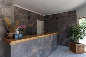 a bathroom with gray tiled walls and a wooden counter at Costa Maya Bodrum in Bodrum City