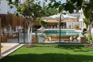 a pool with an umbrella and a bench and a table at Costa Maya Bodrum in Bodrum City