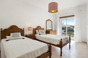 una camera da letto con due letti e uno specchio di Cantinho da Sara a Portimão Altre 95 foto