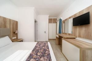 a hotel room with a bed and a flat screen tv at Costa Maya Bodrum in Bodrum City