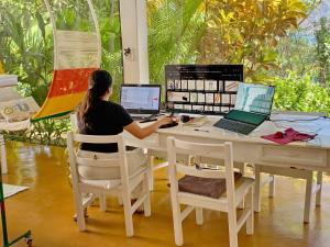 une femme assise sur un bureau avec deux ordinateurs portables dans l'établissement Casa Bella, à La Laguna