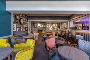 a restaurant with tables and chairs and a bar at The Lodge Hotel in Coleraine
