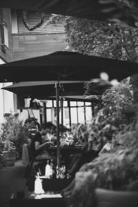 a group of people sitting at a table under an umbrella at Pension Julia & Haus Elisabeth - Wallner's Hofheuriger & Weinhof in Mörbisch am See