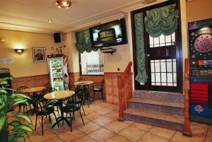 un restaurante con mesas y sillas y un videojuego en Hospedería El Convento, en Estremera