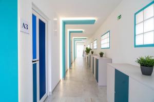 un corridoio di un ufficio con pareti bianche e blu di La Vita Prémium Panzió a Gyula