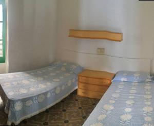 - une chambre avec 2 lits et une table en bois dans l'établissement Apartamento Luminoso y Acogedor Port de La Selva, à El Port de la Selva