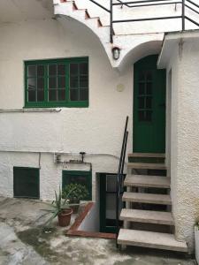 - un bâtiment avec une porte verte et un escalier dans l'établissement Apartamento Luminoso y Acogedor Port de La Selva, à El Port de la Selva