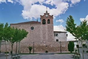 Un edificio con una torre de reloj en la parte superior. en Hospedería El Convento, en Estremera