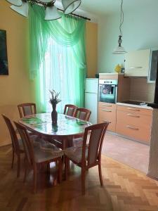 eine Küche mit einem Esstisch mit Stühlen und eine Küche mit einem Tisch in der Unterkunft Family apartment Center in Opatija