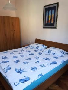 ein Bett mit einer blauen und weißen Bettdecke darauf in der Unterkunft Family apartment Center in Opatija