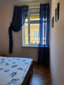 Schlafzimmer mit einem Bett und einem Fenster mit blauen Vorhängen in der Unterkunft Family apartment Center in Opatija