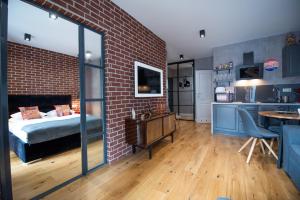 a room with a brick wall and a bed and a kitchen at City Lights Kazimierz in Krakow
