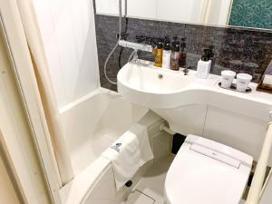 a bathroom with a toilet and a sink at HOTEL LiVEMAX Ikebukuro Ekimae in Tokyo