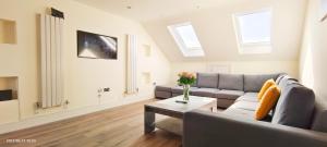 a living room with a couch and a table at Top Floor Flat 5 Northwood in Northwood