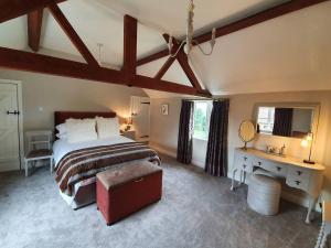 a bedroom with a large bed and a desk and a bed sidx sidx sidx sidx at Paddock Cottage - Thorpe Arnold Melton Mowbray in Melton Mowbray