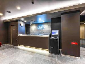 an atm machine in a lobby with a sign at HOTEL LiVEMAX Okazaki in Okazaki