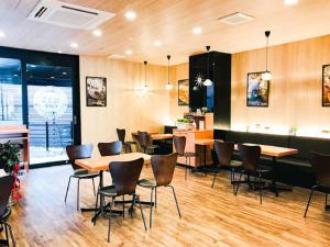 un restaurante con suelo de madera, mesas y sillas en HOTEL LiVEMAX Okazaki, en Okazaki
