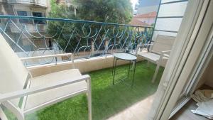 uma varanda com cadeiras e uma mesa na relva em Vilmorin Appartement 1 Chambre proche de gare, plage, centre em Antibes