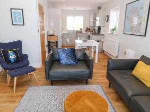 a living room with a couch and two chairs at Beach Apartment 9 in Trearddur