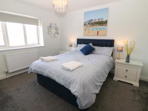 a bedroom with a bed with two towels on it at Beach Apartment 9 in Trearddur