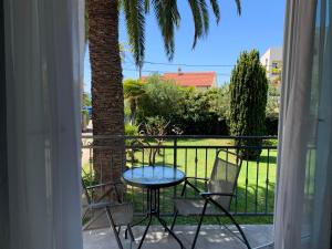 een balkon met een tafel en stoelen en een palmboom bij The48 in Zadar