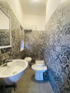 La salle de bains est pourvue d'un lavabo et de toilettes. dans l'établissement Green Gallery Hotel and Restaurant, à Muravera