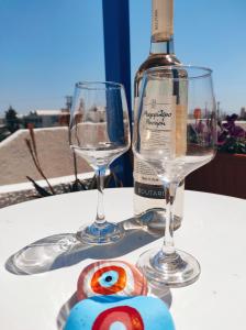 a bottle of wine and two wine glasses on a table at Villa Dioni in Kamari