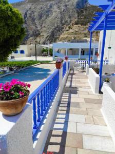 a blue railing next to a swimming pool with flowers at Villa Dioni in Kamari